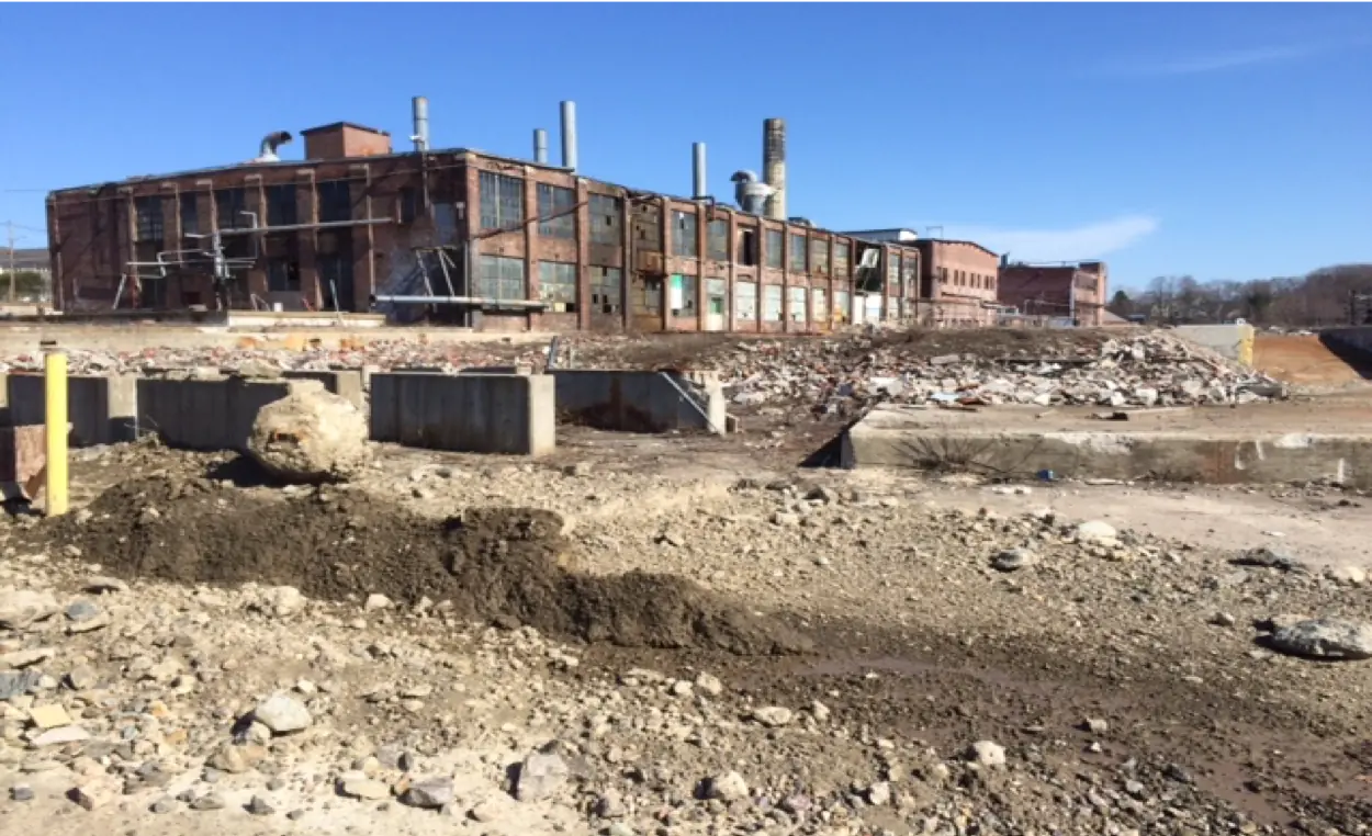 The Plymouth Rubber Company site before redevelopment — industrial buildings and contaminated land in Canton, Massachusetts.