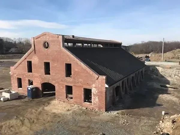 The Copper Rolling Mill during restoration — restored brick walls, new metal roof being installed.